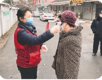 馬麗（左）為居民測量體溫。（馬 麗供圖）