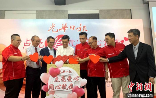 馬來(lái)西亞《光華日?qǐng)?bào)》為支持中國(guó)抗擊疫情舉辦的“點(diǎn)亮愛(ài)心，同心抗疫”義賣(mài)會(huì)。圖為開(kāi)幕儀式上，大家一同把“愛(ài)心”投進(jìn)愛(ài)心箱?！￡悙?攝