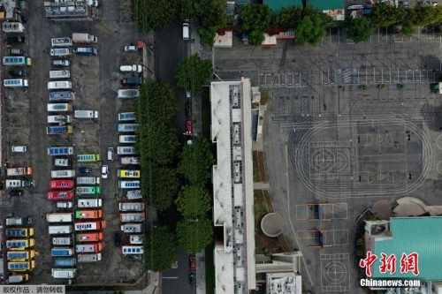 當(dāng)?shù)貢r(shí)間3月23日，食品卡車停在洛杉磯一所空學(xué)校旁邊的停車場(chǎng)。