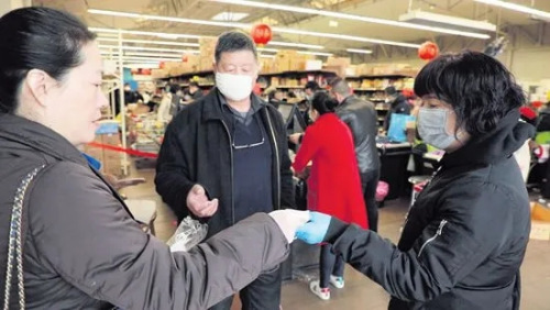巴黎華助中心主任董曉燕(左)在歐拜赫維利耶一間華人超市發(fā)放口罩。(歐洲時(shí)報(bào))