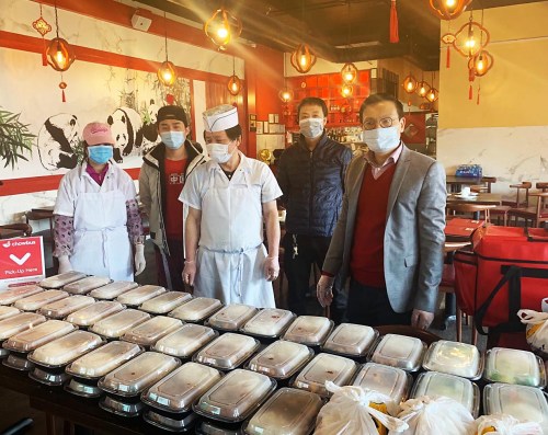 圖為胡曉軍(右一)和會(huì)員們?cè)跍?zhǔn)備外送免費(fèi)餐飲。