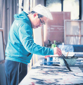 　蔣山青在創(chuàng)作畫作。