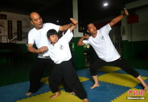 余丹秋指導9歲的鄭施澤學習鳴鶴拳。呂明攝