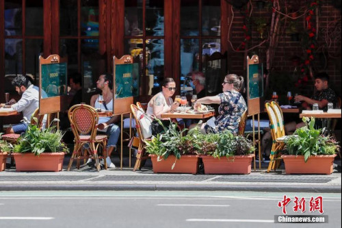 當地時間6月22日，紐約曼哈頓一家餐廳，顧客在戶外用餐。當日，紐約市按預定計劃進入第二階段重啟，市政府預計將有約30萬人重返工作崗位。<a target='_blank' >中新社</a>記者 廖攀 攝