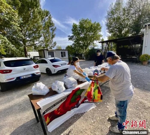 意大利華僑在佛羅倫薩擺攤，給有需要的當(dāng)?shù)鼐用穹职l(fā)生活物資?！±顐タ倒﹫D