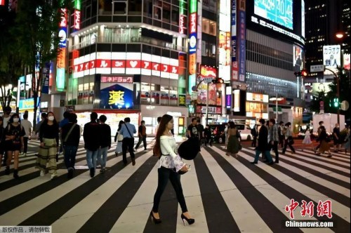 資料圖：5月15日，日本解除緊急事態(tài)宣言，人們穿過東京新宿區(qū)的一條街道。（<a target='_blank'  >中新網(wǎng)</a>）