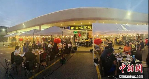 加拿大時(shí)間7月18日晚上，大多倫多地區(qū)華人聚居區(qū)萬(wàn)錦市，一家中餐館開(kāi)起了露天大排檔，不僅有燒烤啤酒，還有樂(lè)隊(duì)駐場(chǎng)演出。<a target='_blank' >中新社</a>記者 余瑞冬 攝