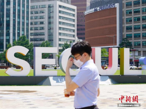 　6月23日，一位韓國首爾市民經(jīng)過首爾廣場。 <a target='_blank' >中新社</a>記者 曾鼐 攝