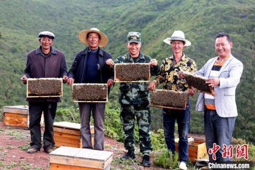 布哈與村民展示養(yǎng)蜂成果。圖片由武警部隊提供