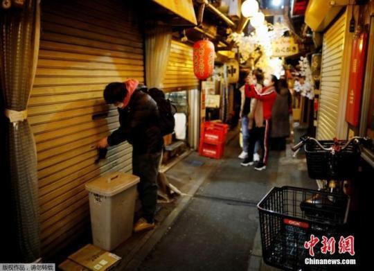 資料圖：當(dāng)?shù)貢r(shí)間2021年1月8日，日本東京，一位工作人員鎖上了店門。