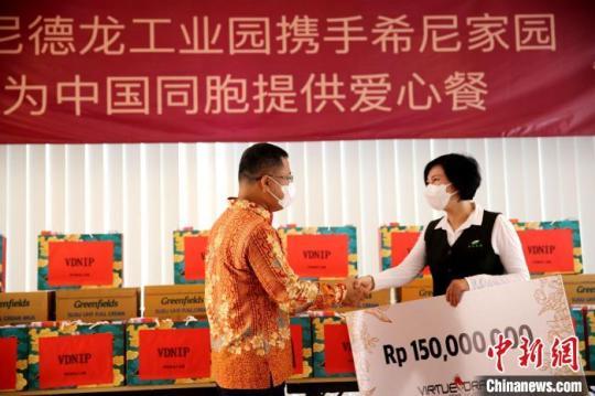 圖為徐捷向希尼家園負(fù)責(zé)人佟桐女士提供愛心支票。　印尼德龍工業(yè)園 供圖