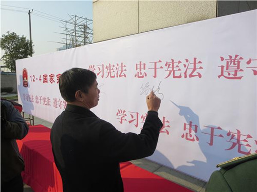 中國僑網(wǎng)市僑辦華生新副主任在遵守憲法、法律承諾墻上簽名