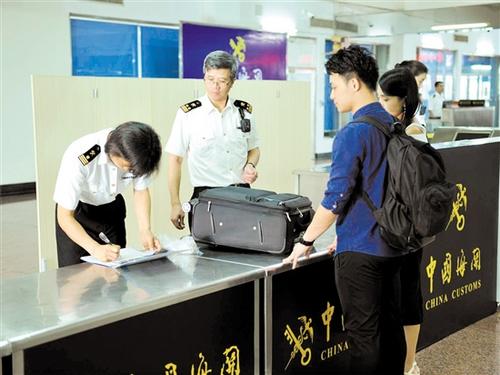 中國僑網(wǎng)海關(guān)關(guān)員在檢查進(jìn)境旅客行李物品。