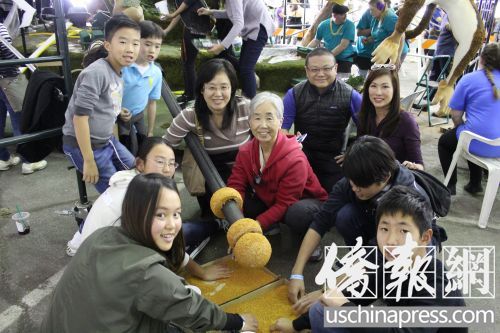 中國僑網(wǎng)趙奶奶(紅衣)和她的一家三代在為金箍棒涂膠粘貼草籽。(美國《僑報(bào)》/高睿 攝)