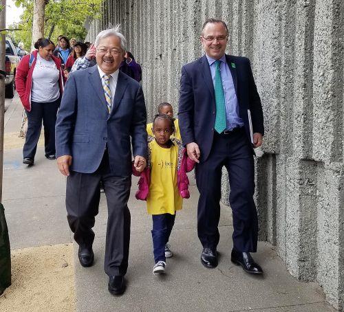 中國僑網(wǎng)舊金山市長李孟賢(左)和公共土地信托城市公園主任貝納普(右),帶著一名兒童步行前往山頂公園。(美國《僑報》/市長李孟賢辦公室提供)