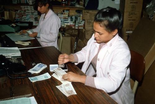 中國(guó)僑網(wǎng)一名工作人員點(diǎn)數(shù)聯(lián)邦糧食券。(美國(guó)《世界日?qǐng)?bào)》/Getty圖片)