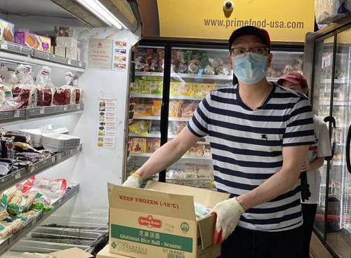 中國僑網(wǎng)吳建錫在超市搬貨(美國《世界日報》/牟蘭 攝)