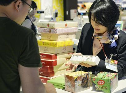 成田機場免稅店內(nèi)一名店員正在應(yīng)對外國游客購物。(共同社)