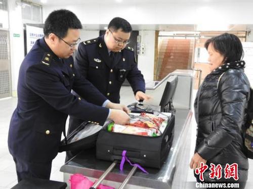 中國僑網(wǎng)檢驗(yàn)檢疫人員在查驗(yàn)旅客出境行李 高明出入境檢驗(yàn)檢疫局供圖 攝