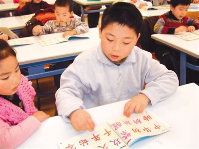 圖為丹華學(xué)生正在認讀《中華字經(jīng)》上的漢字