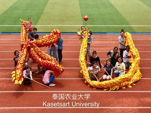 中國僑網(wǎng)舞龍課擺出泰國農(nóng)業(yè)大學(xué)英文簡寫造型。