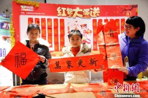中國(guó)僑網(wǎng)資料圖:游客用寫春聯(lián)的方式迎接新年的來(lái)臨?!珡┛?攝