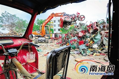中國僑網(wǎng)工人對風(fēng)采車進(jìn)行切割銷毀。 本報(bào)記者 袁琛 攝