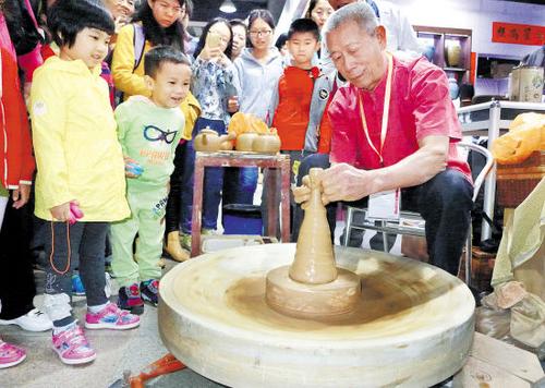 中國僑網(wǎng)資料圖:黃樹藩現(xiàn)場展示手拉朱泥壺陶藝 (來源:羊城晚報)