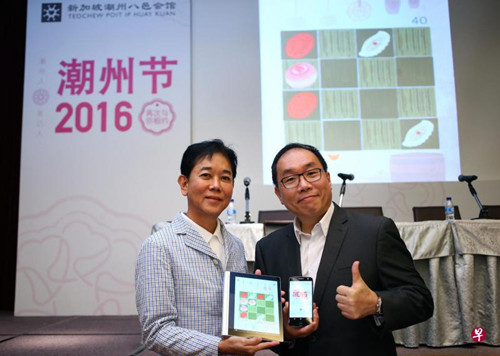 潮州八邑會館會長郭明忠(左)和潮州節(jié)籌委會主席林雍杰所展示的手機游戲“Heng