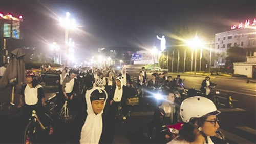 中國僑網“周五夜騎團”身穿熊貓裝騎行在成都街頭。(資料圖)