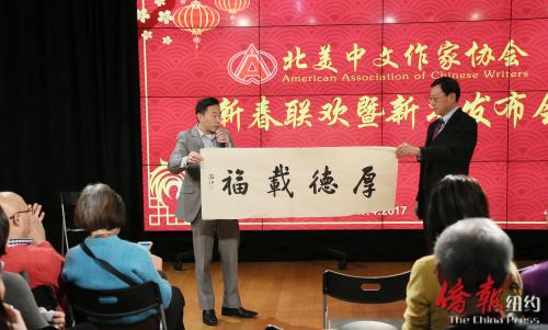 中國僑網《僑報》總裁游江捐贈自己的書法作品作為聯(lián)歡活動的獎品之一。(美國《僑報》/管黎明 攝)