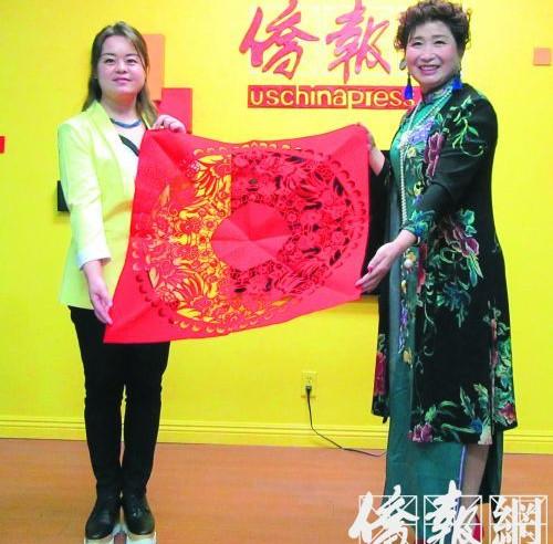 中國僑網(wǎng)田亞莉(右)來到僑報(bào)大樓接受專訪和展示她的剪紙藝術(shù)作品。(美國《僑報(bào)》/翁羽 攝)