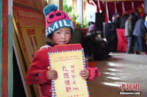 中國僑網(wǎng)資料圖:藏族小朋友手持春聯(lián)。孫翔 攝