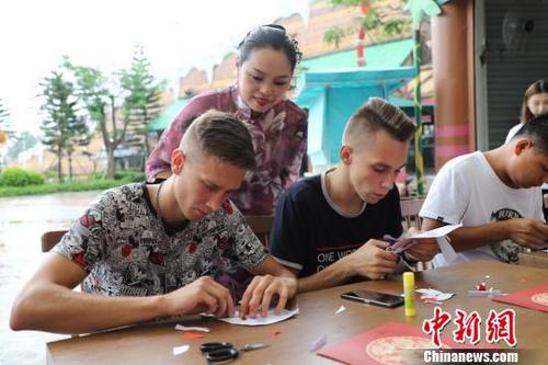中國僑網饒寶蓮正在指導“洋徒弟”剪紙 李星凱 攝